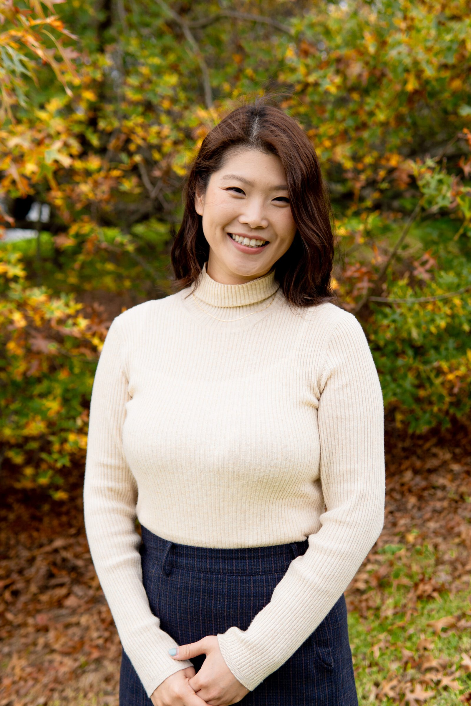 A Psychologist Smiling Asian in a cream turtleneck | living hope psychology (ADHD Assessment Auckland)